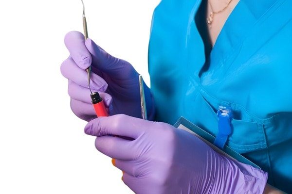 Dental technician working with orthodontic tools, close-up of hands in purple gloves preparing custom dental products, innovative dental solutions from EXAmedic productos odontológicos personalizados.